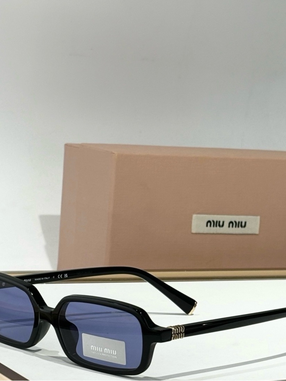 Miu Miu Black Frame Sunglasses with Blue Lenses and Gold Accents